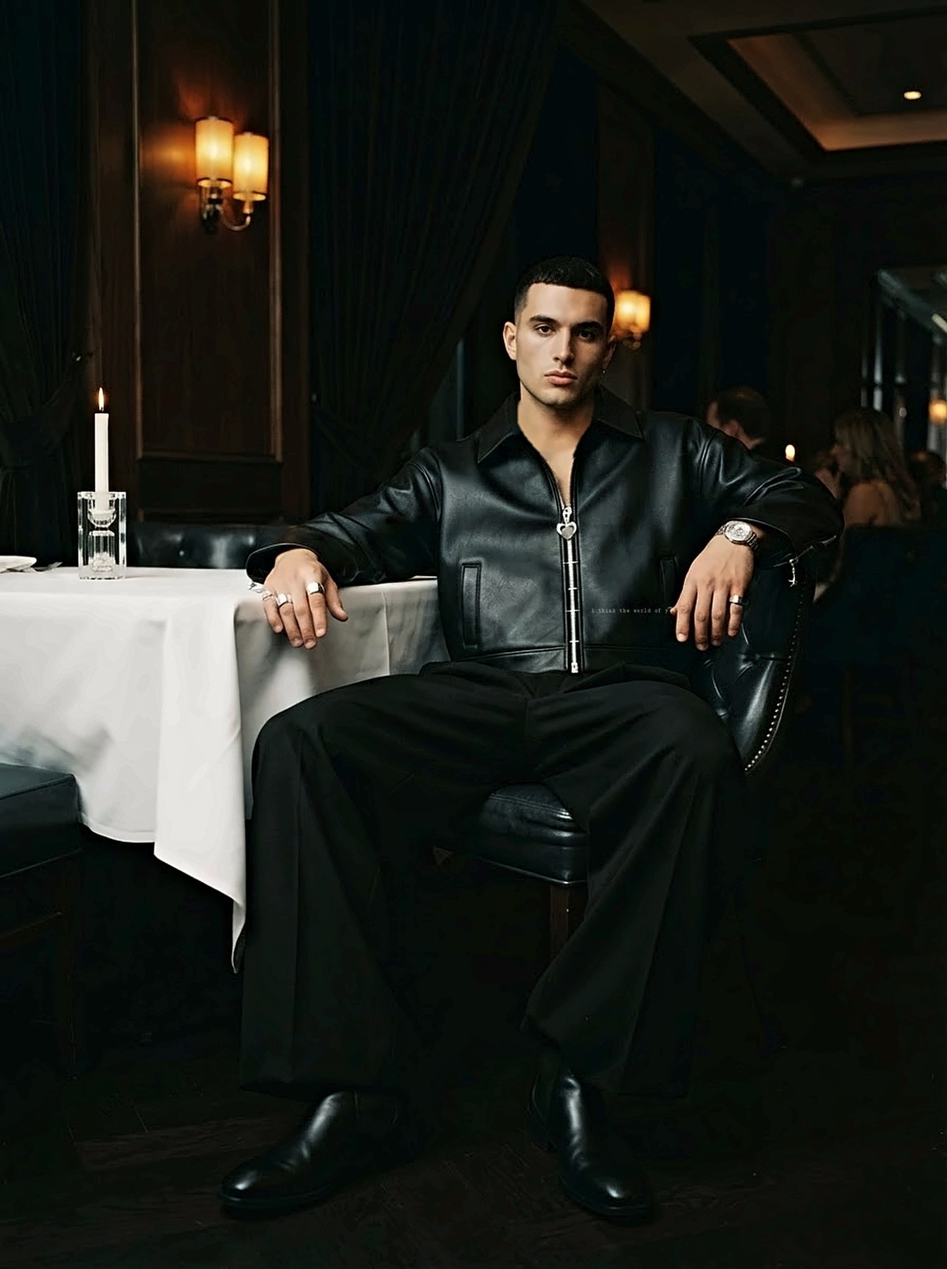 A man seated at a white tablecloth wearing the jacket